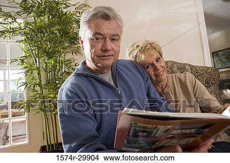 Picture - Portrait of a mature couple sitting together and holding a book. Fotosearch