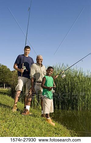 Portrait of a mature man with his son and friend holding fishing rods by lake View Large Photo Image Stock Image - Portrait of a mature man with his son and friend holding fishing rods by lake. Fotosearch