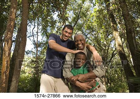 Portrait of a mature man with his son and friend smiling at forest View Large Photo Image Stock Photograph - Portrait of a mature man with his son and friend smiling at forest. Fotosearch
