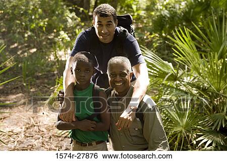 Portrait of a mature man with his son and friend smiling at forest View Large Photo Image Stock Photograph - Portrait of a mature man with his son and friend smiling at forest. Fotosearch