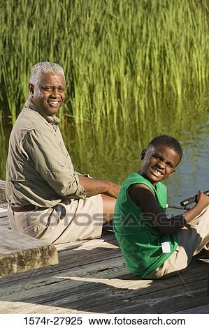 Portrait of a mature man with his son sitting on jetty View Large Photo Image Stock Photography - Portrait of a mature man with his son sitting on jetty. Fotosearch