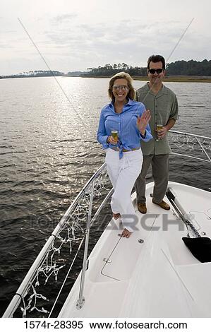 Portrait of a mid adult couple standing with glass of champagne at bow of a boat View Large Photo Image Stock Photography - Portrait of a mid adult couple standing with glass of champagne at bow of a boat. Fotosearch