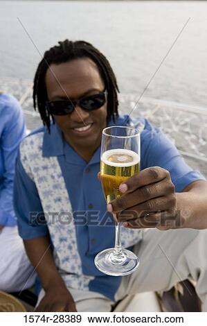 Portrait of a mid adult man holding glass of champagne View Large Photo Image Stock Photo - Portrait of a mid adult man holding glass of champagne. Fotosearch