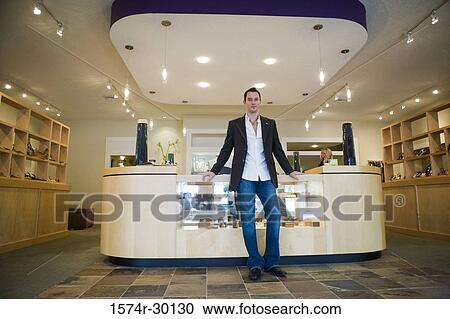 Portrait of a mid adult man standing in a store View Large Photo Image Stock Image - Portrait of a mid adult man standing in a store. Fotosearch