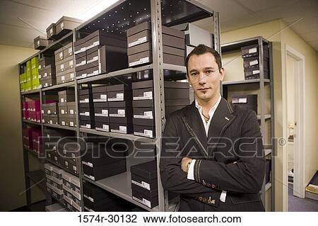 Portrait of a mid adult man standing in a storage room View Large Photo Image Stock Image - Portrait of a mid adult man standing in a storage room. Fotosearch