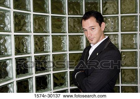 Portrait of a mid adult man standing in front of glass bricks View Large Photo Image Stock Photo - Portrait of a mid adult man standing in front of glass bricks. Fotosearch