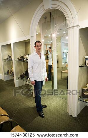 Portrait of a mid adult man standing in a store View Large Photo Image Stock Photography - Portrait of a mid adult man standing in a store. Fotosearch