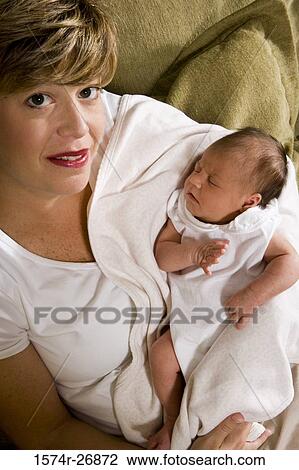 Portrait of a mid adult woman holding her baby in hands View Large Photo Image Stock Image - Portrait of a mid adult woman holding her baby in hands. Fotosearch