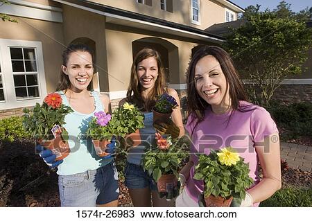 Portrait of a mother holding potted plant with her daughters in garden View Large Photo Image Stock Image - Portrait of a mother holding potted plant with her daughters in garden. Fotosearch