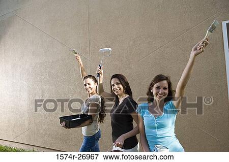 Portrait of a mother with her daughters with paint can and brushes standing by wall View Large Photo Image Stock Photo - Portrait of a mother with her daughters with paint can and brushes standing by wall. Fotosearch