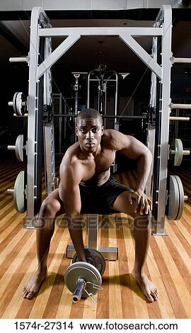 Portrait of a shirtless young man working out with dumbbells View Large Photo Image Picture - Portrait of a shirtless young man working out with dumbbells. Fotosearch