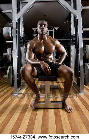 Portrait of a shirtless young man sitting in the gym View Large Photo Image Picture - Portrait of a shirtless young man sitting in the gym. Fotosearch