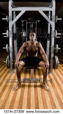 Portrait of a shirtless young man sitting in the gym View Large Photo Image Stock Photo - Portrait of a shirtless young man sitting in the gym. Fotosearch