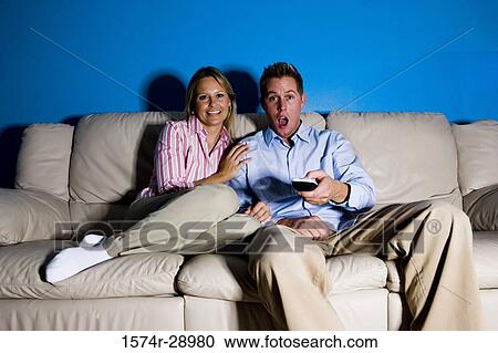 Portrait of a shocked mid adult couple sitting on a sofa with remote control View Large Photo Image Stock Image - Portrait of a shocked mid adult couple sitting on a sofa with remote control. Fotosearch