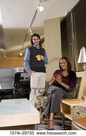 Portrait of a smiling businessman and a businesswoman holding tea cup in an office View Large Photo Image Stock Image - Portrait of a smiling businessman and a businesswoman holding tea cup in an office. Fotosearch