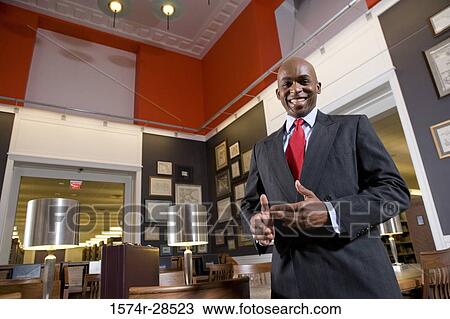 Portrait of a smiling businessman standing in an office View Large Photo Image Stock Image - Portrait of a smiling businessman standing in an office. Fotosearch