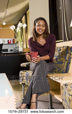 Portrait of a smiling businesswoman holding tea cup in an office View Large Photo Image Stock Image - Portrait of a smiling businesswoman holding tea cup in an office. Fotosearch
