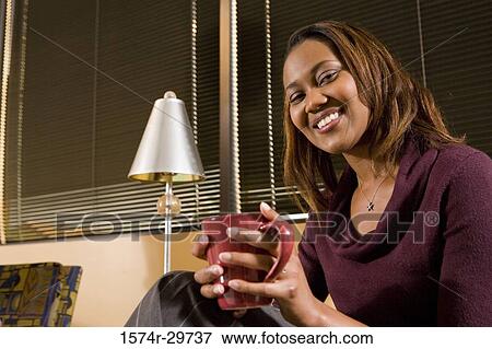 Portrait of a smiling businesswoman holding tea cup in an office View Large Photo Image Stock Photo - Portrait of a smiling businesswoman holding tea cup in an office. Fotosearch