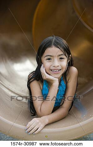 Portrait of a smiling girl lying on tunnel slide with hand on chin View Large Photo Image Stock Photo - Portrait of a smiling girl lying on tunnel slide with hand on chin. Fotosearch