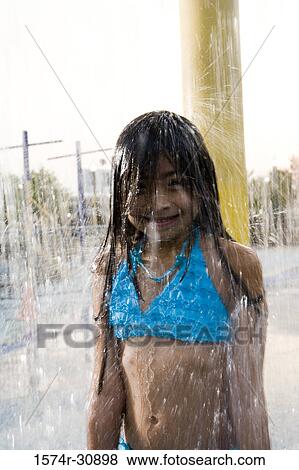 Stock Photo - Portrait of a smiling girl under a shower. Fotosearch