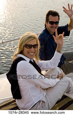 Portrait of a smiling mid adult couple gesturing on the deck of a boat View Large Photo Image Stock Photography - Portrait of a smiling mid adult couple gesturing on the deck of a boat. Fotosearch