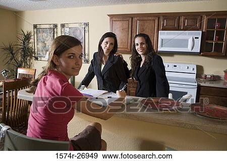 Portrait of a teenage girl with her mother and sister by kitchen countertop View Large Photo Image Stock Photo - Portrait of a teenage girl with her mother and sister by kitchen countertop. Fotosearch