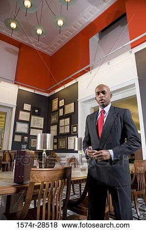 Portrait of a well-dressed businessman standing in an office View Large Photo Image Stock Photo - Portrait of a well-dressed businessman standing in an office. Fotosearch