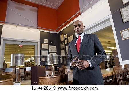 Stock Photo - Portrait of a well-dressed businessman standing in an office. Fotosearch