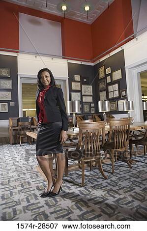 Portrait of a well-dressed businesswoman leaning by a conference table in an office View Large Photo Image Stock Photo - Portrait of a well-dressed businesswoman leaning by a conference table in an office. Fotosearch