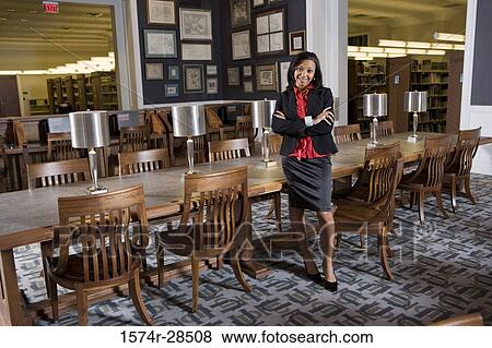 Portrait of a well-dressed businesswoman leaning by a conference table in an office View Large Photo Image Stock Photo - Portrait of a well-dressed businesswoman leaning by a conference table in an office. Fotosearch