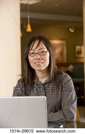 Stock Image - Portrait of a young businesswoman working on laptop. Fotosearch
