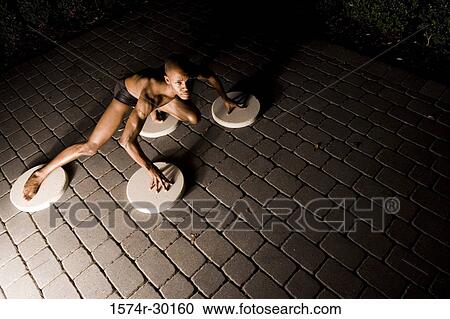 Portrait of a young man crouching on the round tiles View Large Photo Image Stock Image - Portrait of a young man crouching on the round tiles. Fotosearch