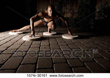 Portrait of a young man crouching on the round tiles View Large Photo Image Stock Image - Portrait of a young man crouching on the round tiles. Fotosearch