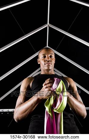 Stock Photo - Portrait of a young man holding ribbons. Fotosearch