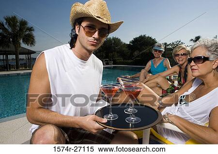 Portrait of a young man holding tray of drinks by senior women View Large Photo Image Stock Photography - Portrait of a young man holding tray of drinks by senior women. Fotosearch