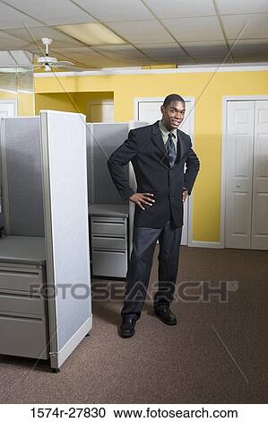 Portrait of a young man in full suit standing in an office View Large Photo Image Stock Image - Portrait of a young man in full suit standing in an office. Fotosearch