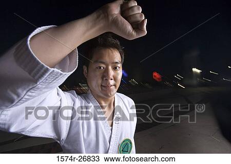 Portrait of a young man practicing martial art in sports uniform on the road View Large Photo Image Stock Image - Portrait of a young man practicing martial art in sports uniform on the road. Fotosearch