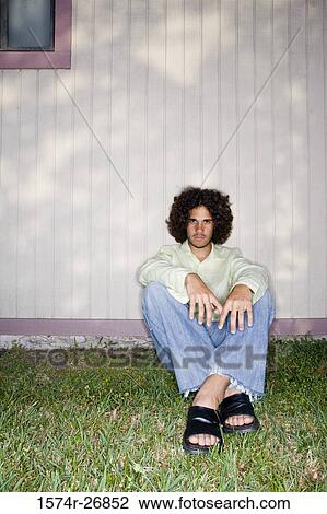 Portrait of a young man sitting on the backyard of a house View Large Photo Image Stock Image - Portrait of a young man sitting on the backyard of a house. Fotosearch