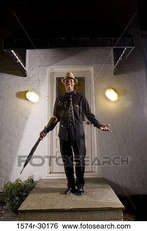 Portrait of a young man standing in front of the door and holding an umbrella View Large Photo Image Stock Photograph - Portrait of a young man standing in front of the door and holding an umbrella. Fotosearch