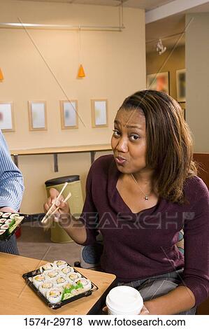 Portrait of a young woman eating food View Large Photo Image Stock Photo - Portrait of a young woman eating food. Fotosearch