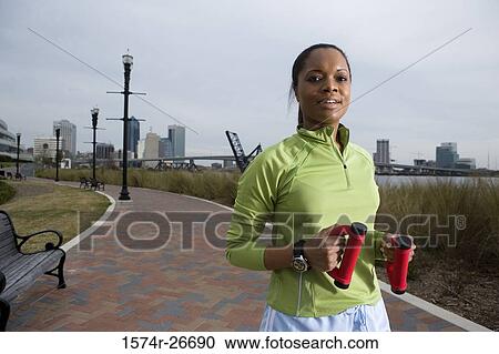 Portrait of a young woman in sports clothing jogging on walkway View Large Photo Image Stock Image - Portrait of a young woman in sports clothing jogging on walkway. Fotosearch