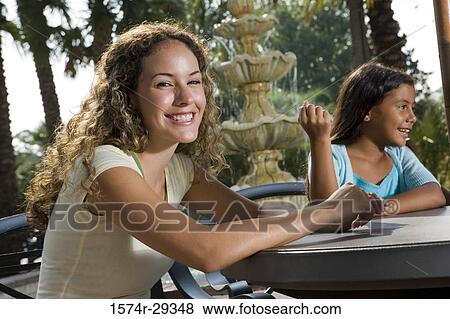 Portrait of a young woman smiling by daughter View Large Photo Image Stock Photo - Portrait of a young woman smiling by daughter. Fotosearch