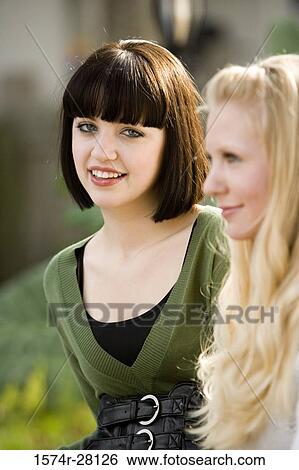 Stock Photograph - Portrait of a young woman smiling by mid adult woman. Fotosearch