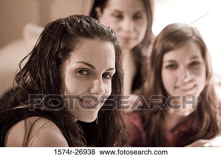 Portrait of a young woman smiling with her sister and mother View Large Photo Image Stock Photo - Portrait of a young woman smiling with her sister and mother. Fotosearch