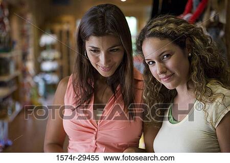 Stock Photography - Portrait of a young woman standing with her friend. Fotosearch