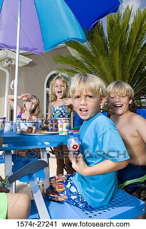 Portrait of boys and girls sitting by table and holding plaything View Large Photo Image Stock Image - Portrait of boys and girls sitting by table and holding plaything. Fotosearch