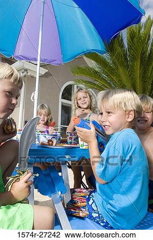 Portrait of boys and girls sitting by table and holding plaything View Large Photo Image Stock Image - Portrait of boys and girls sitting by table and holding plaything. Fotosearch