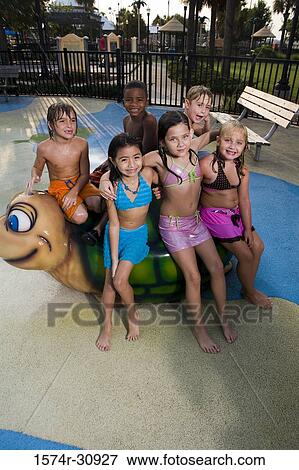 Portrait of boys and girls sitting together on a tortoise sculpture View Large Photo Image Stock Photo - Portrait of boys and girls sitting together on a tortoise sculpture. Fotosearch