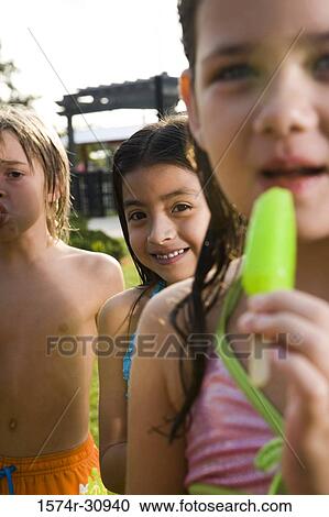Portrait of boys and girls standing together and eating flavored ice View Large Photo Image Stock Image - Portrait of boys and girls standing together and eating flavored ice. Fotosearch