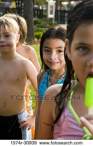 Portrait of boys and girls standing together and eating flavored ice View Large Photo Image Stock Photo - Portrait of boys and girls standing together and eating flavored ice. Fotosearch
